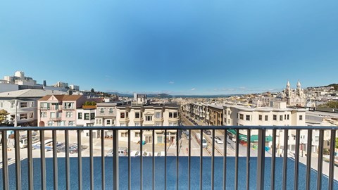 A view from a balcony overlooking a pool and a cityscape.