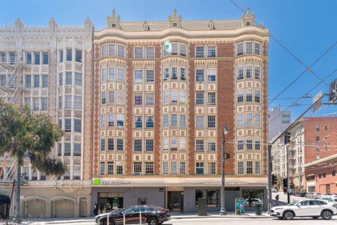 A large, multi-story building with a sign that reads "HIGH ALT" in front of it.