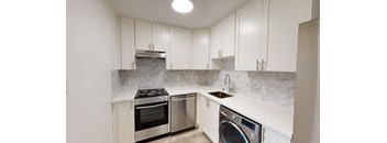 a kitchen with white cabinets and stainless steel appliances