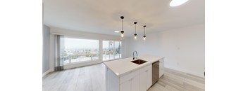 a kitchen with white cabinets and a large window and a white counter top