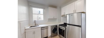 a kitchen with white cabinets and stainless steel appliances