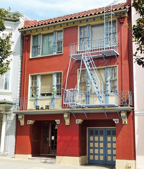 a red building with a fire escape on the side of it