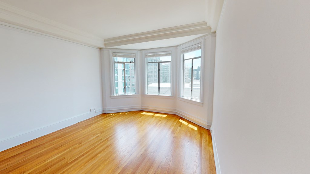 an empty living room with white walls and wood floors
