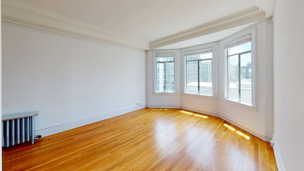 an empty living room with wood floors and windows