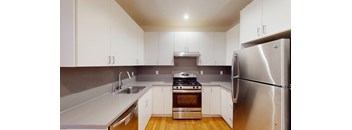 a kitchen with white cabinets and stainless steel appliances