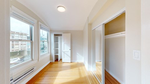 a living room with a large window and a wood floor