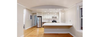 a kitchen with a white counter top and a refrigerator
