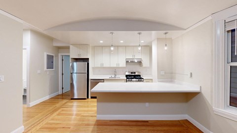 a kitchen with a white counter top and a refrigerator