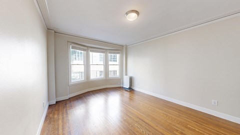 A room with a window and a fan.