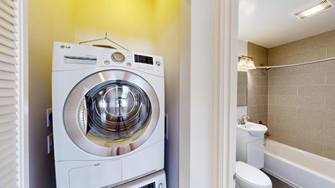 A white LG washing machine in a small bathroom.