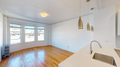A kitchen with a white counter top and a window.