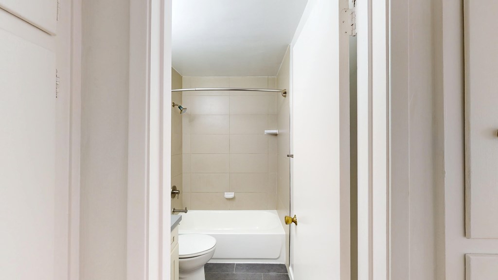 A white bathroom with a toilet, sink and bathtub.