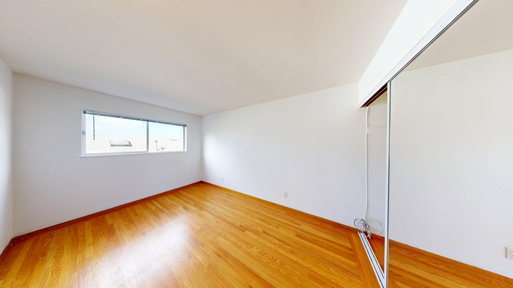 A room with wooden floors and a window.