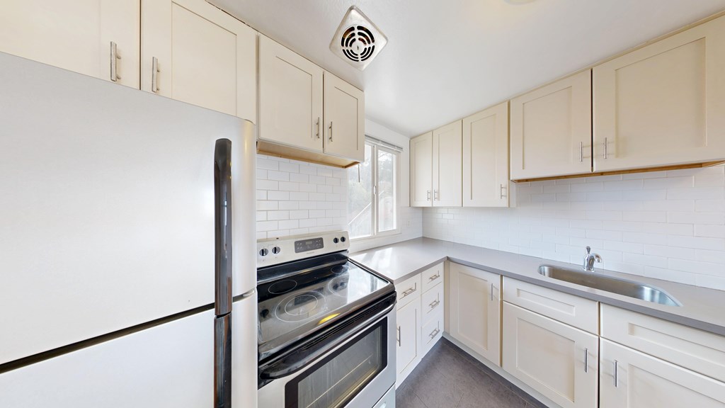 A kitchen with white appliances and cabinets.