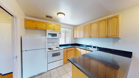 A kitchen with white appliances and wooden cabinets.