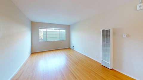 A room with wooden flooring and a window.