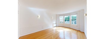 an empty living room with white walls and wood floors