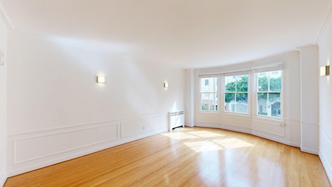 an empty living room with white walls and wood floors