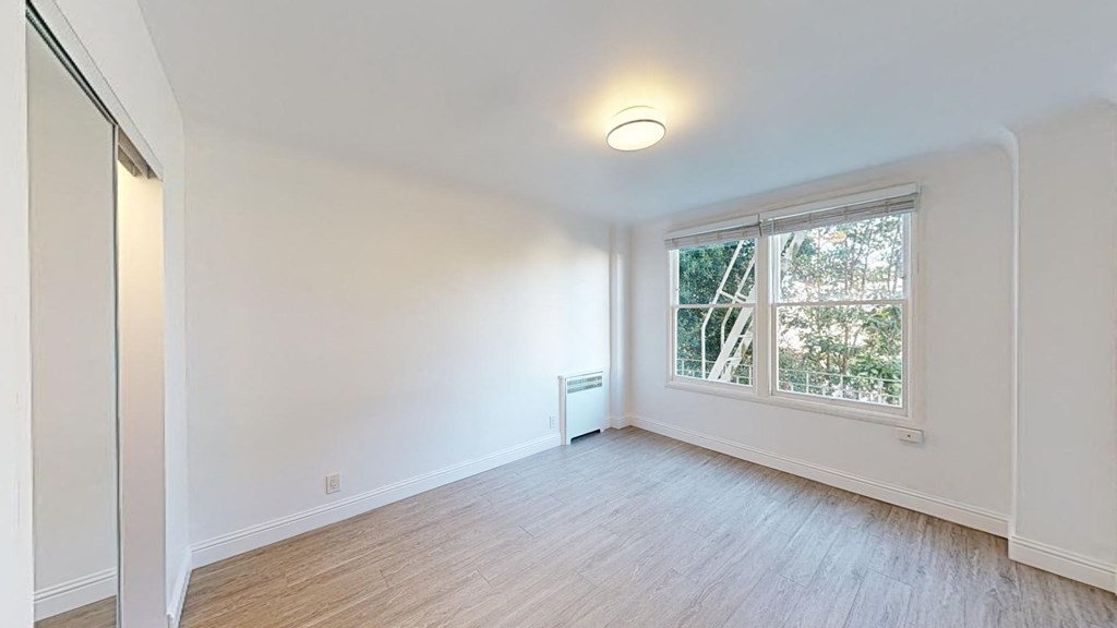 an empty room with a large window and white walls