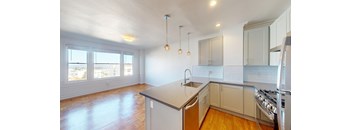 an empty kitchen with white cabinets and a large island