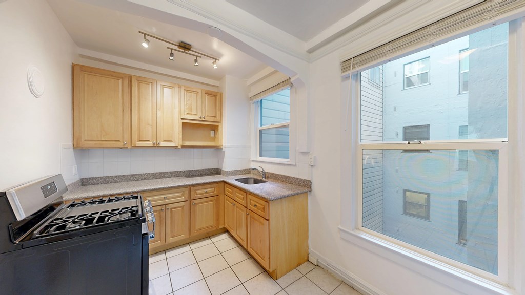A kitchen with wooden cabinets and a black stove top oven.