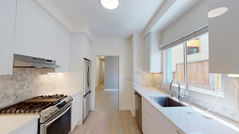 a kitchen with white cabinets and stainless steel appliances and a sink