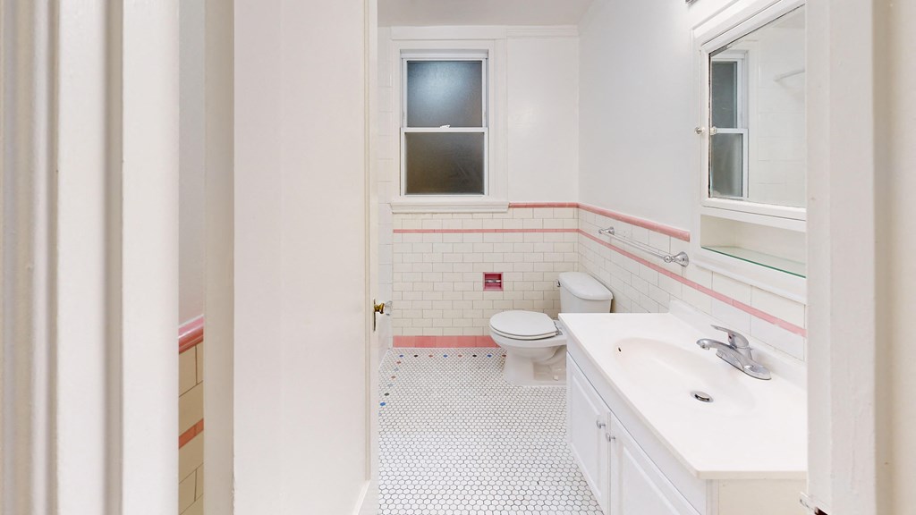 a bathroom with a toilet and a sink and a window