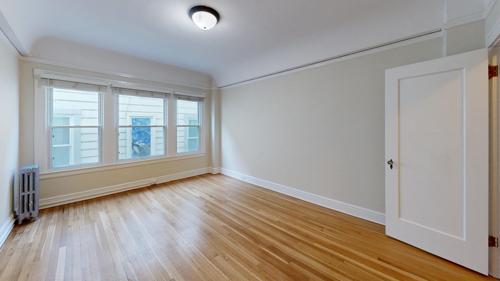 an empty living room with wood floors and a white door