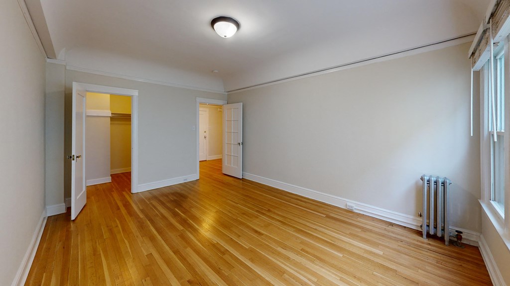 an empty living room with wood floors and white walls