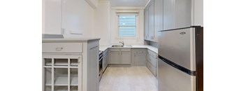 a kitchen with white cabinets and stainless steel appliances