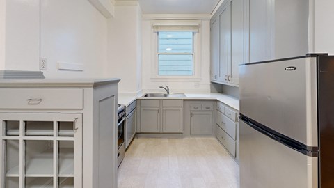 a kitchen with white cabinets and stainless steel appliances