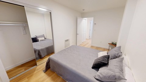 A bedroom with a bed and a mirror on the wall.