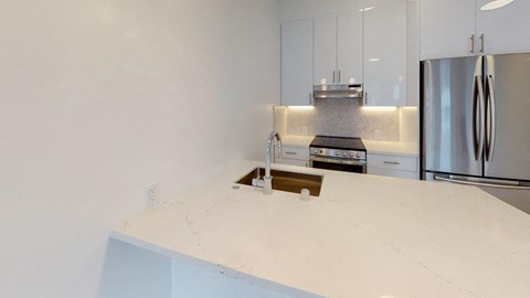 a kitchen with white counter tops and a sink