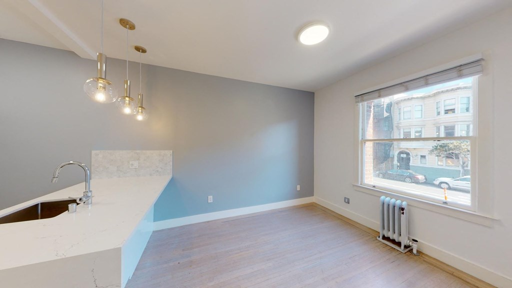 a kitchen with a large window and a white counter top