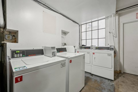 Laundry room with washing machines neatly arranged on a wooden floor