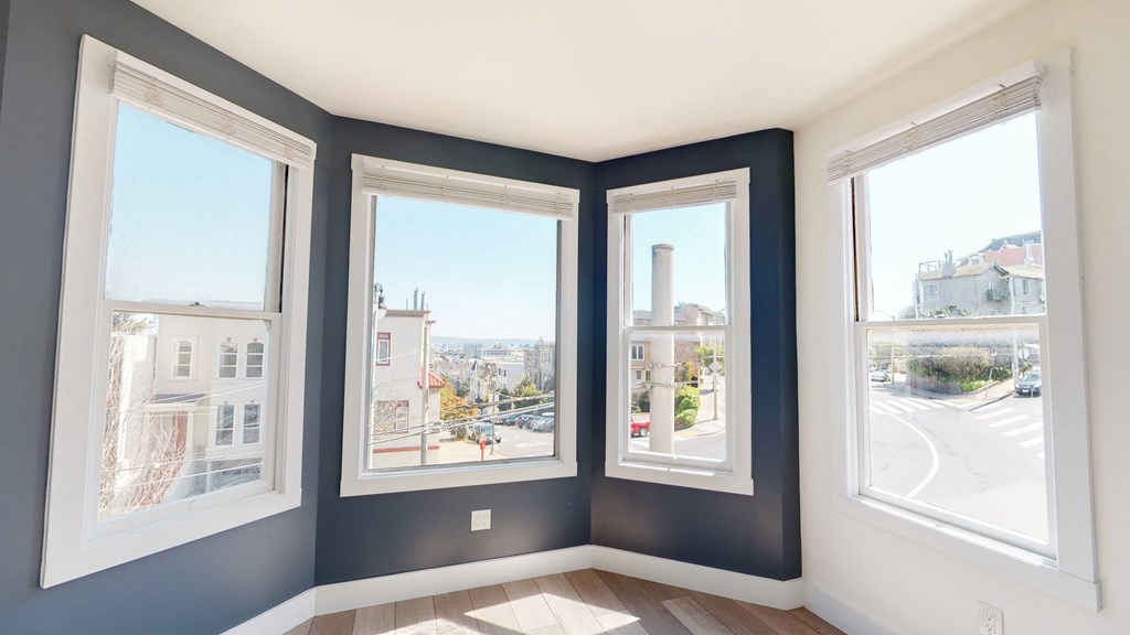 a living room with four windows and a view of the city
