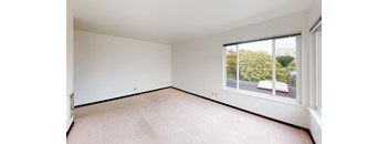 a bedroom with a large window and white walls