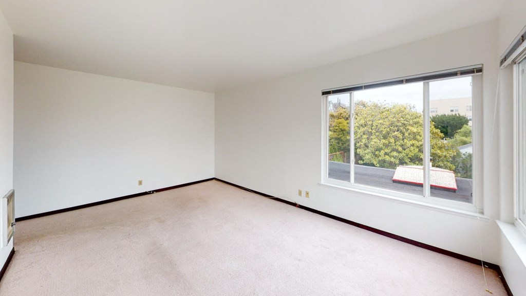 a bedroom with a large window and white walls