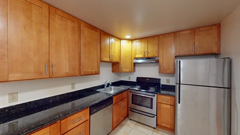 A kitchen with wooden cabinets and a black countertop.