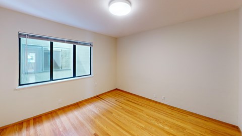 A room with a window and wooden floor.
