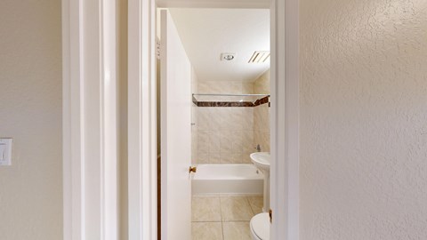 A white bathroom with a toilet, sink and bathtub.