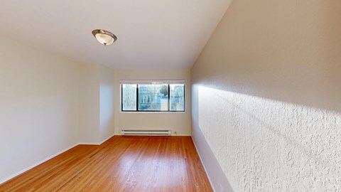 A room with a window and a radiator on the wall.