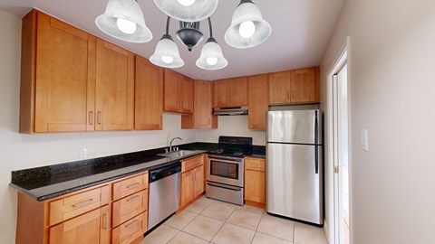 A kitchen with wooden cabinets and a stainless steel refrigerator.