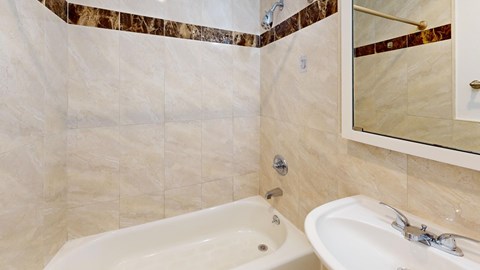 A white sink with a silver faucet is in a bathroom with a marble border.