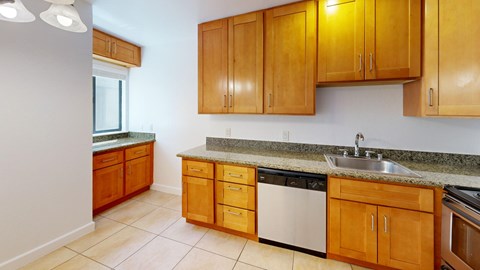A kitchen with wooden cabinets and a granite countertop.