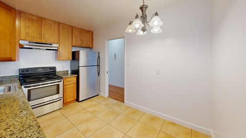 A kitchen with a refrigerator, oven, and microwave.
