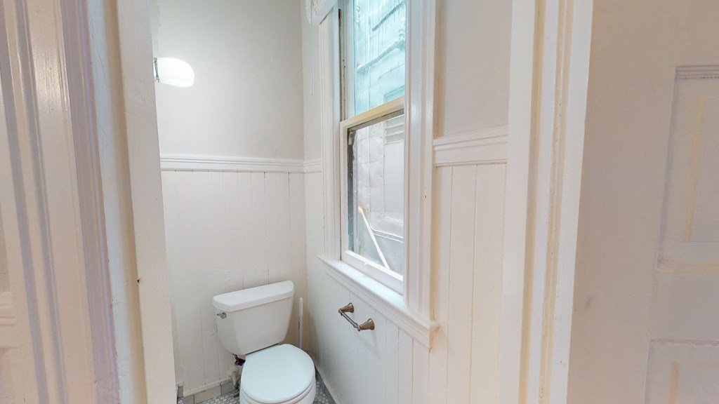 a small bathroom with a toilet and a window