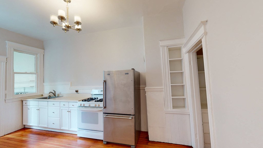 a kitchen with white cabinets and a stainless steel refrigerator