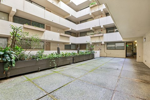 A courtyard with a concrete floor and a building in the background.