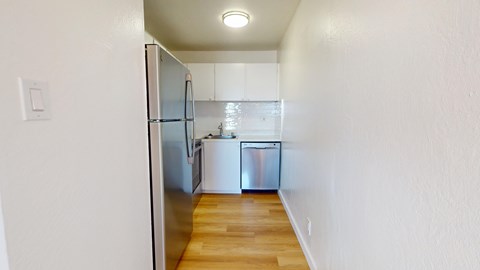 A kitchen with a refrigerator and a sink.